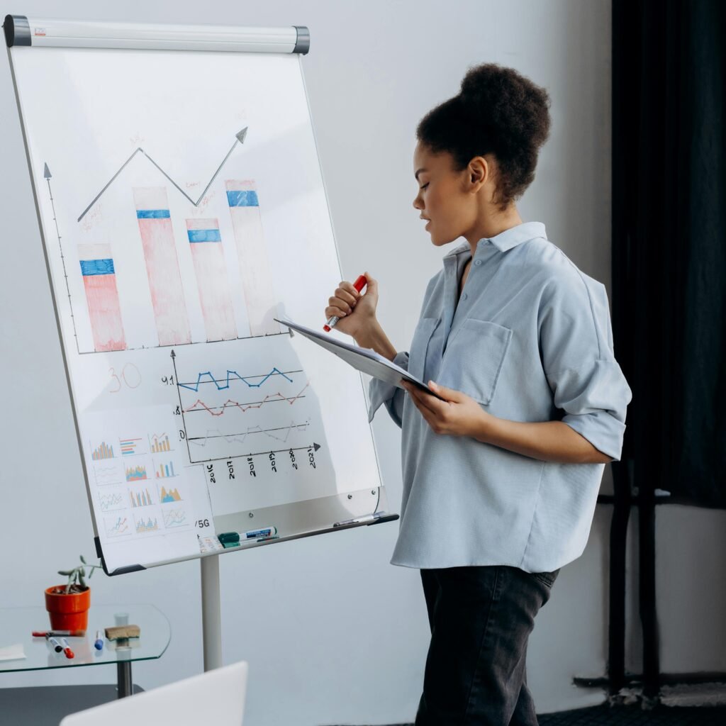 Professional businesswoman presenting data analytics on a flipchart in a modern office.